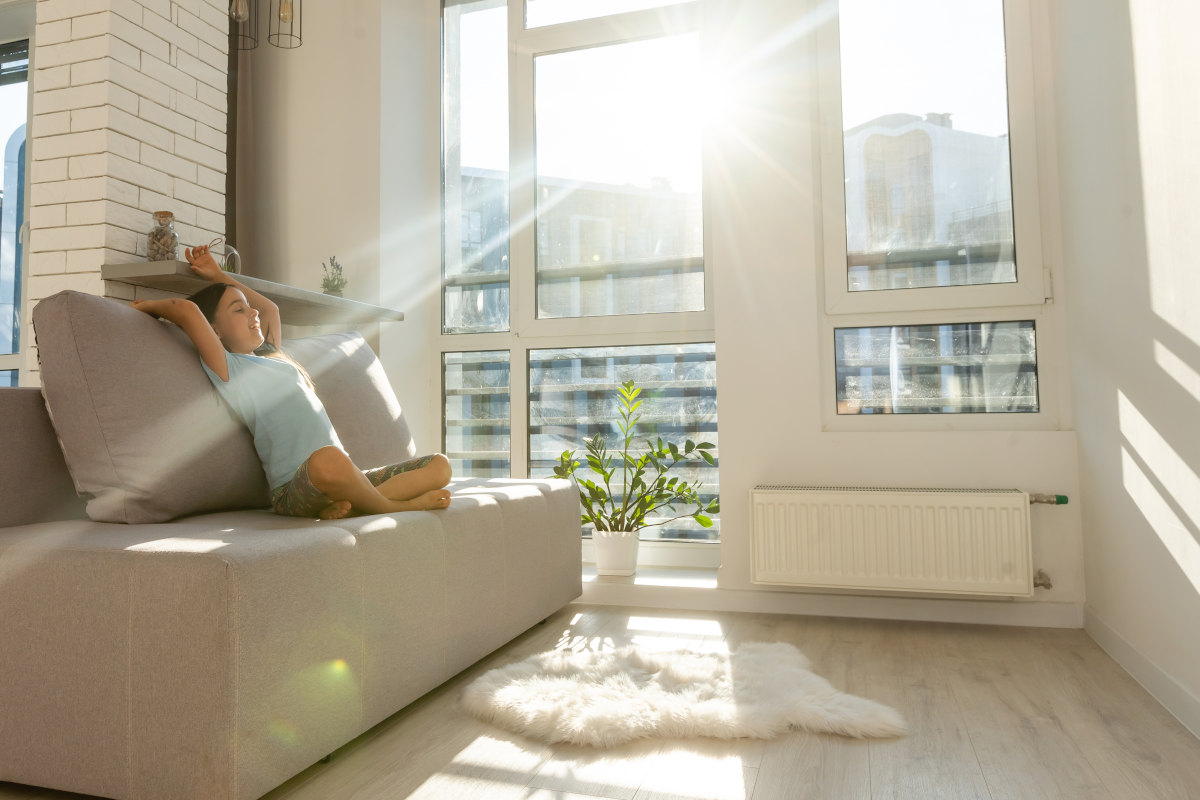 Kind sitzt zufrieden auf einem Sofa in einem hellen Raum